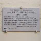 Tra due finestre laterali notiamo una targa. Si tratta di una dedica a Piero Delfino Pesce: fu lui a dedicarsi personalmente alla cura del palazzo e soprattutto del suo rigoglioso giardino